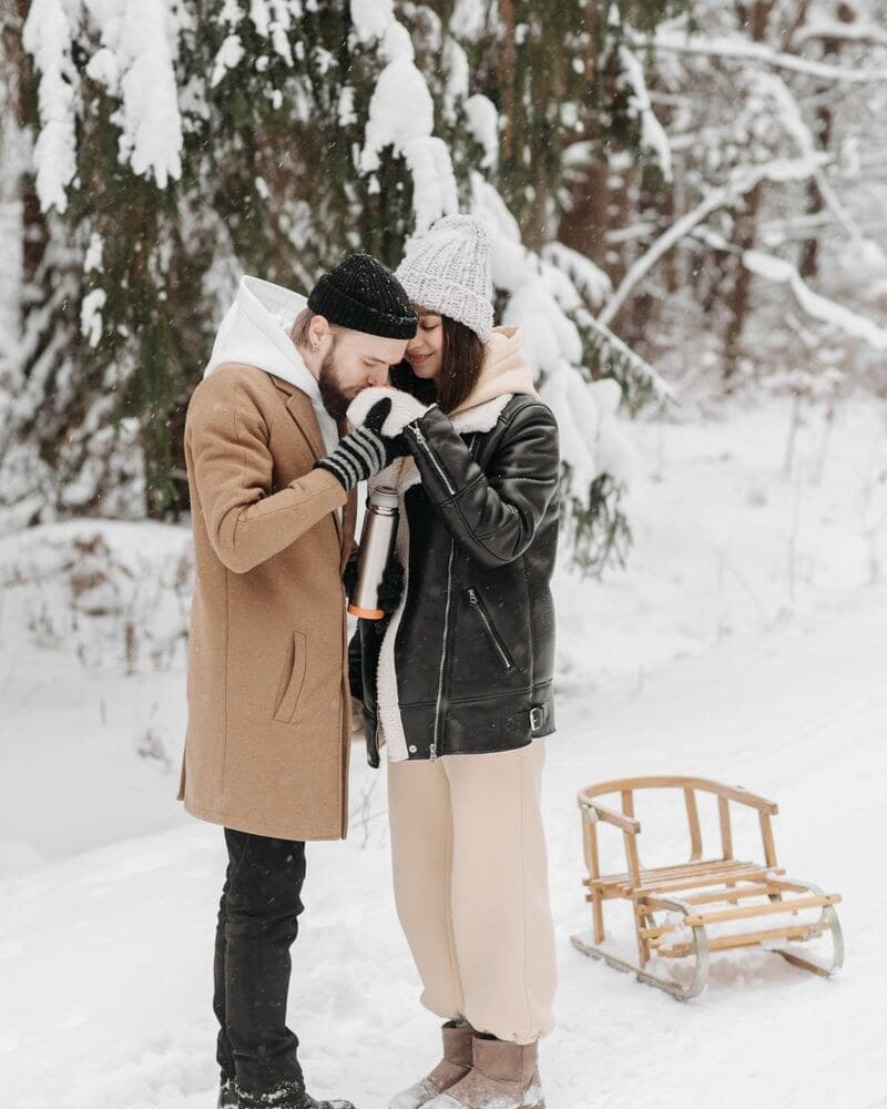 Couple sharing a cozy winter date in the snow
